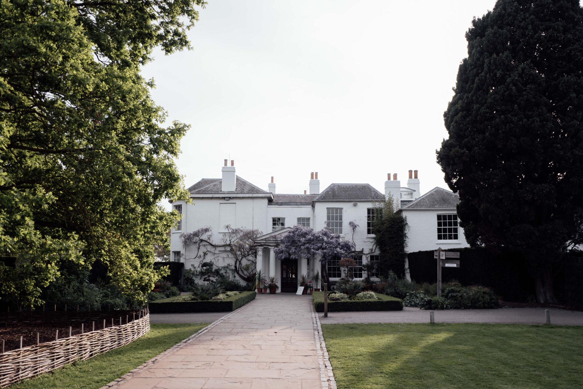 The Pembroke Lodge entrance with soft lighting, Wisteria and green lawns.