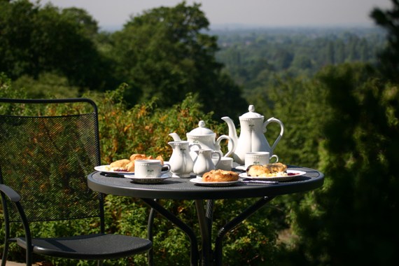 Afternoon tea served on a black metal outdoor table.