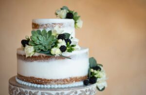 A close up of a three tiered cake with berry decorations.