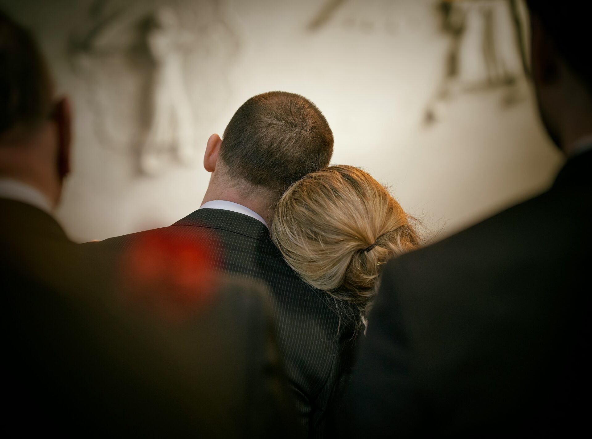 A man and a woman dressed in black leaning on oneanother.