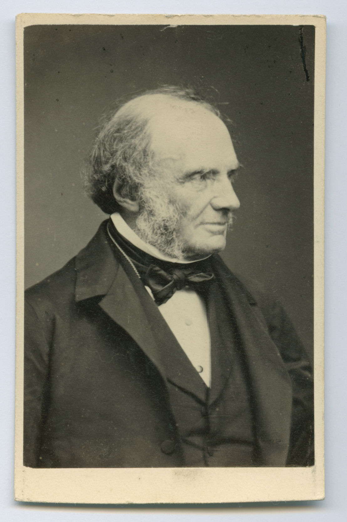 Black and white portrait of Lord John Russell in 19th-century attire, with sideburns and a bow tie. He gazes thoughtfully to the right. Vintage tone.