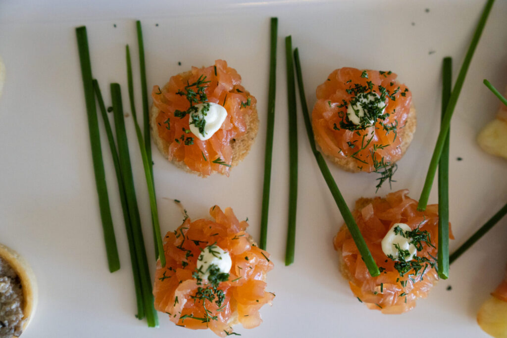 An aerial view of crustinis with smoked salmon and chives.