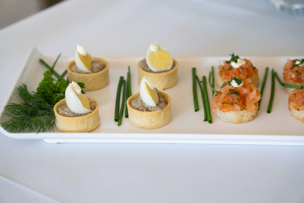A white square plate with various hors d'oeuvres.
