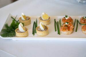A white square plate with various hors d'oeuvres.