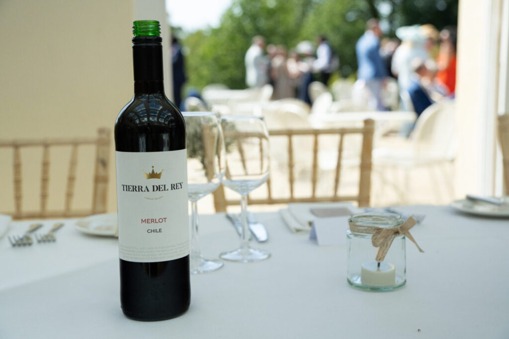 A close up of a wine bottle and candle on a table. The wine label reads Tierra Del Rey.