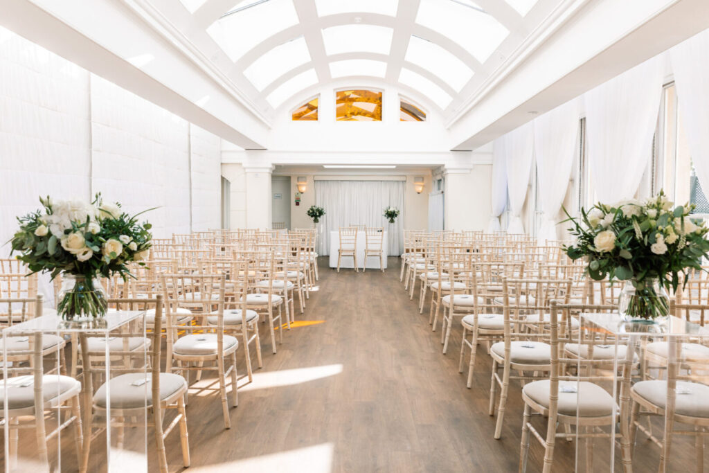A spacious room with an arched roof and rows of wooden chairs.