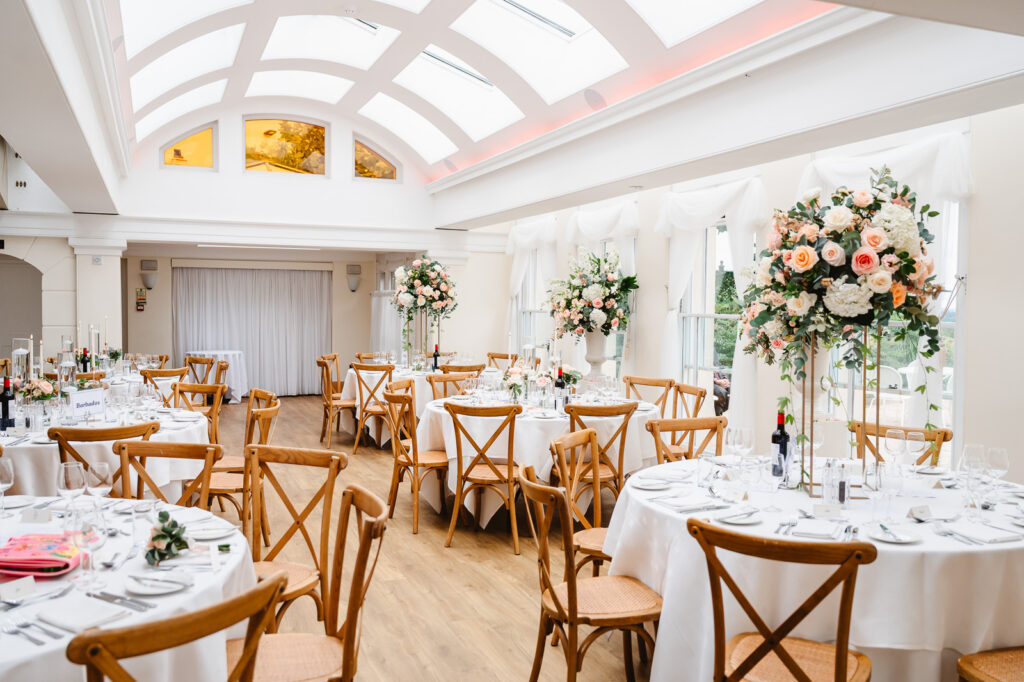 A room with round tables surrounded by wooden chairs.