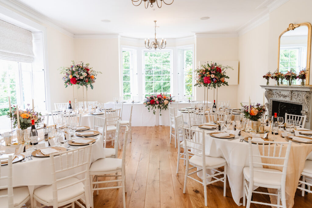 An inviting wedding reception room showcasing white chairs and tables.