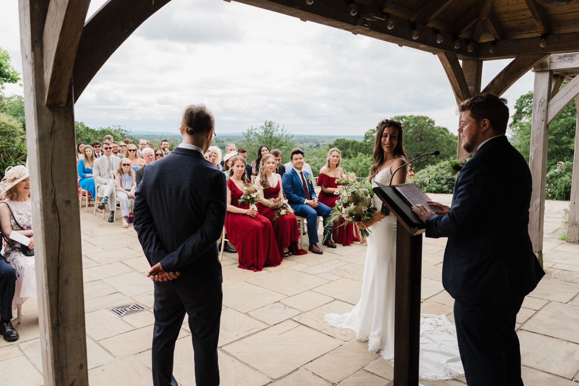 A bride and groom standing opposite eachother on a large patio.