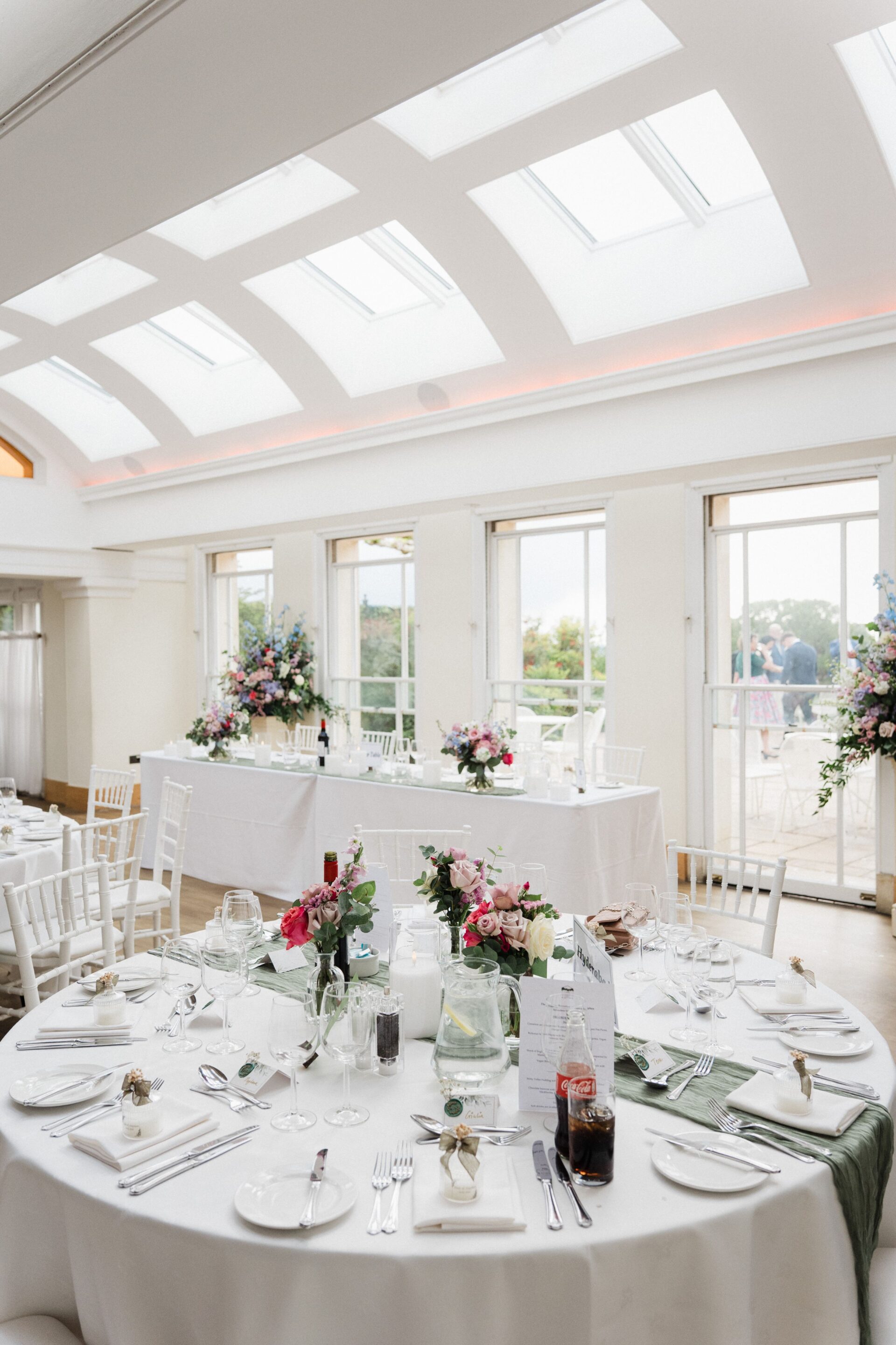 Round dining tables arranged in a large bright room.