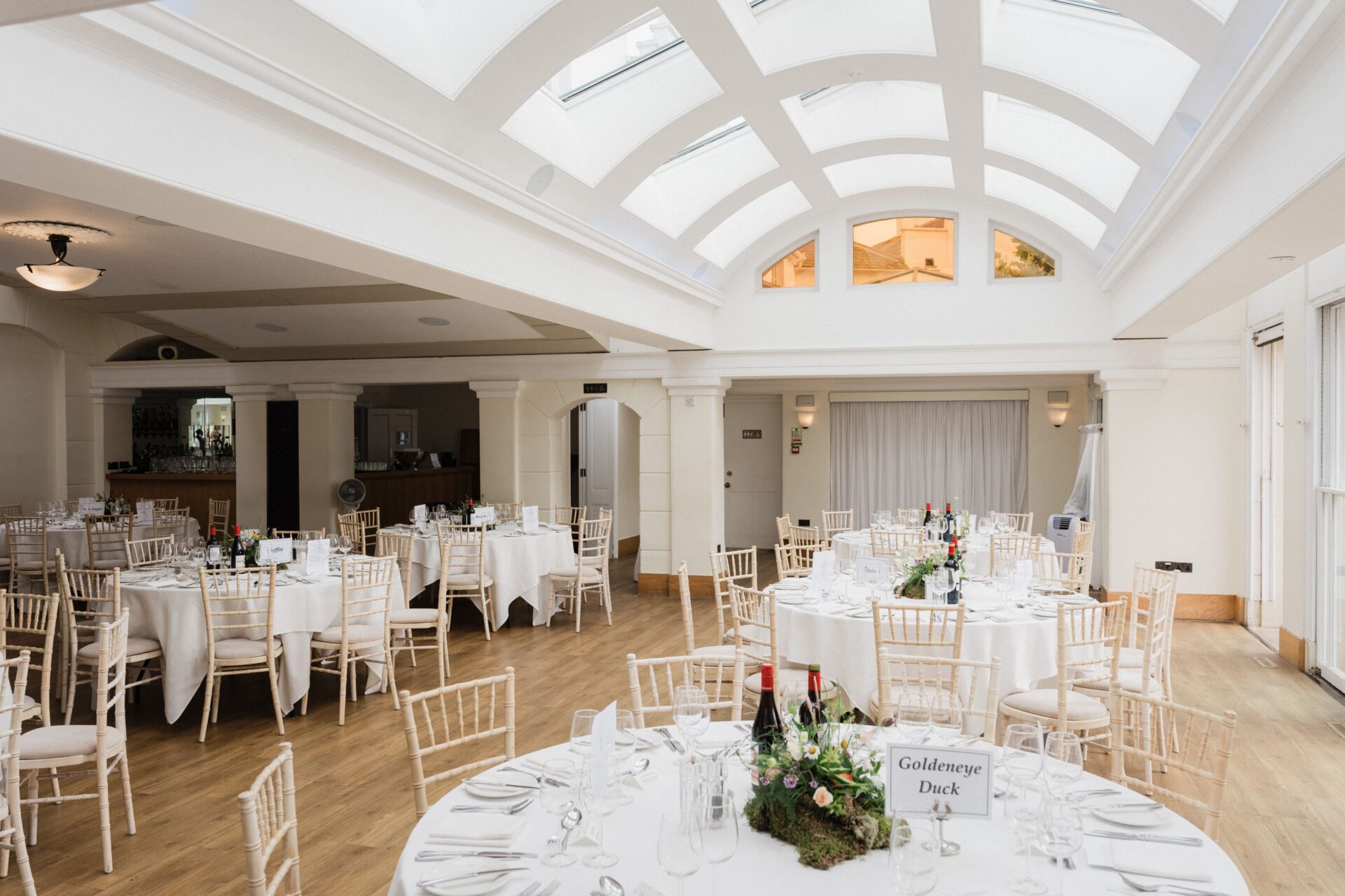 Rows of white tables and in a modern well lit room.